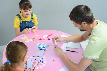 Image showing Family plays board games at the table, top view