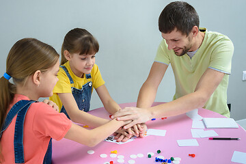 Image showing Dad and kids have fun playing a board game