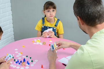 Image showing Daughter funny looks at dad, playing a board game at the table