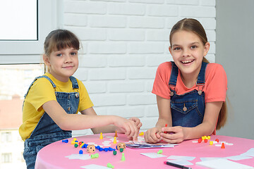 Image showing Two girls play a board game and looked at the frame