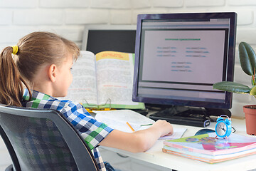 Image showing Girl doing homework on the computer at home