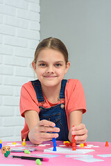 Image showing Girl plays board games, sits at a table at home