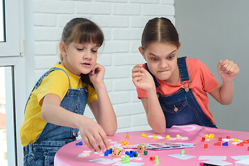 Image showing Girls play board games, one of them looks funny at the chips