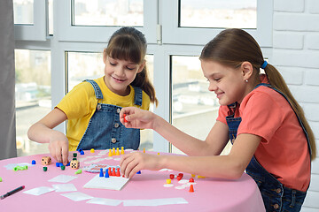 Image showing Two happy girls spend home leisure playing games