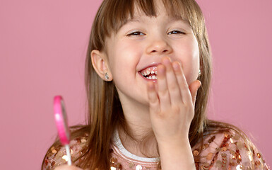 Image showing Adorable young girl posing with pink lollypop candy. Smiling to the camera with all happyness