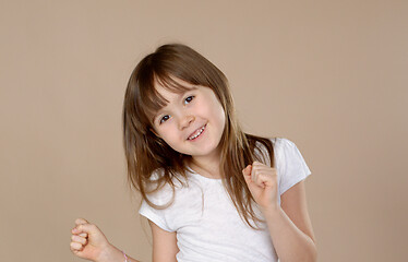 Image showing Cute little girl in white tshirt dancing, smiling and having fun in studio session