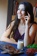 Image showing Vegan woman sitting at the table with healthy food