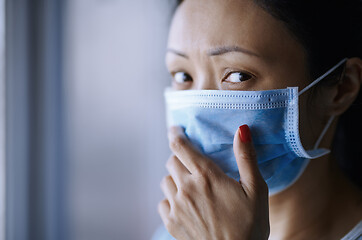 Image showing Woman staying at home wearing protective surgical mask