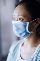 Image showing Woman staying at home wearing protective surgical mask