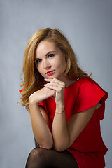 Image showing Spectacular girl in red dress looks pensively in the frame