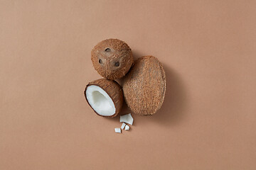 Image showing Three fresh natural organic coconut fruits on a brown background.