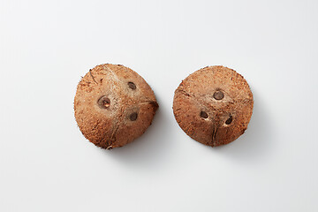 Image showing Two whole parts of brown natural tropical coconut fruit on a grey background.