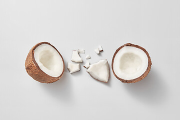 Image showing Two halves of fresh natural organic coconut fruit on a light grey background.