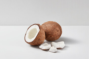 Image showing Composition from parts of fresh ripe natural coconuts fruits on a grey background.