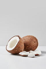 Image showing Set from natural ripe coconut fruits with half and pieces on a grey background.