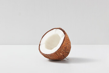 Image showing Half of fresh ripe tropical coconut fruits on light grey background.