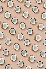 Image showing Vertical pattern from ripe tropical coconut\'s halves on a beige background.