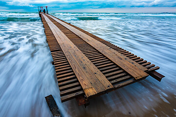 Image showing Pier going to sea and sea surf after sunset