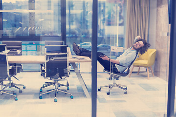 Image showing young businessman relaxing at the desk