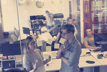 Image showing young couple at modern office interior writing notes on stickers