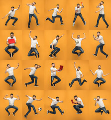 Image showing Image of young man over orange background using laptop computer while jumping.