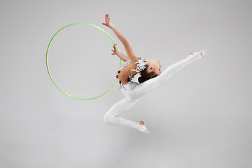 Image showing The teenager girl doing gymnastics exercises isolated on white background