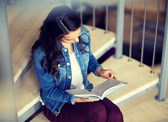 Image showing high school student girl reading book on stairs