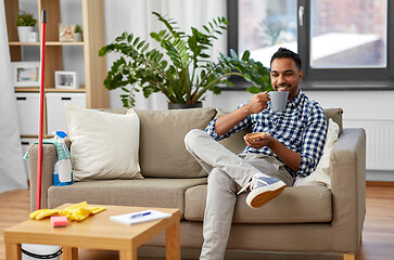 Image showing indian man drinking coffee after home cleaning