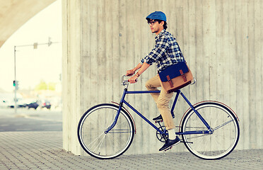 Image showing young hipster man with bag riding fixed gear bike