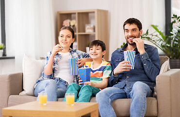 Image showing happy family with popcorn watching tv at home