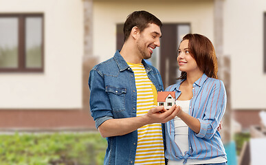 Image showing smiling couple holding house model