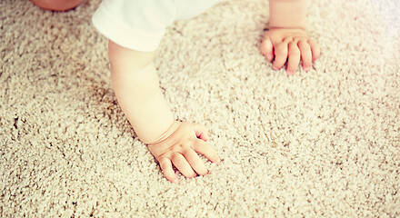 Image showing hands of baby crawling on floor or carpet