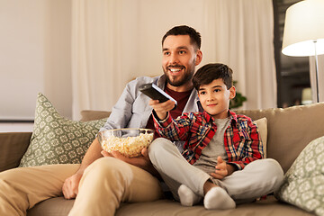 Image showing father and son with popcorn watching tv at home