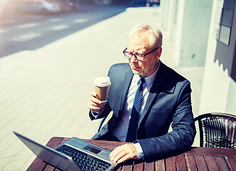 Image showing senior businessman with laptop drinking coffee