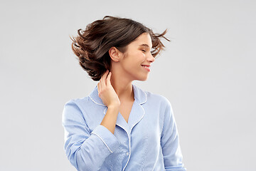 Image showing happy young woman in pajama over grey background