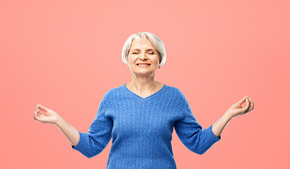 Image showing smiling senior woman in blue sweater chilling