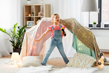Image showing little girl with toy microphone singing at home
