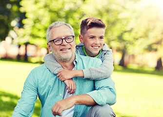 Image showing grandfather and grandson hugging at summer park