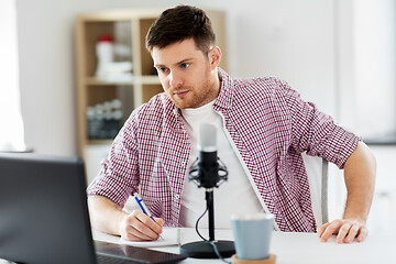 Image showing audio blogger with laptop, microphone and notebook