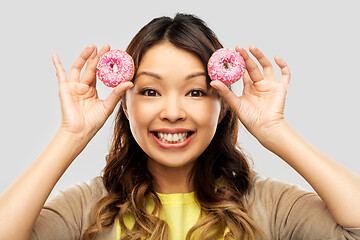 Image showing happy asian woman with donuts