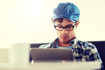 Image showing man with tablet pc sitting at cafe table