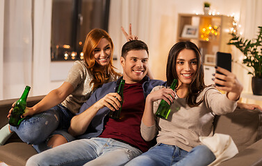 Image showing friends clinking drinks and taking selfie at home