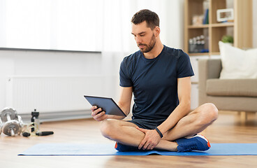 Image showing man with tablet computer on exercise mat at home