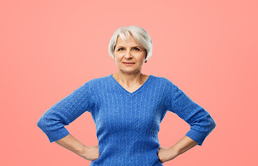 Image showing senior woman in blue sweater hands on hips