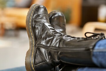 Image showing Leather boots legs up on a chair