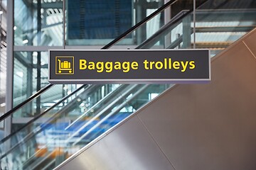 Image showing Airport terminal signs, luggage trolleys