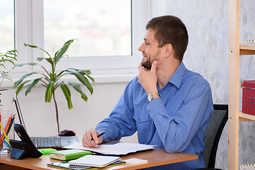 Image showing Office worker joyfully looks out the window while waiting for the weekend