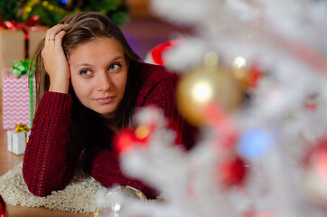 Image showing portrait of a beautiful brooding girl behind a Christmas tree