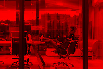 Image showing young businessman relaxing at the desk