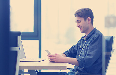 Image showing Young casual businessman using smartphone